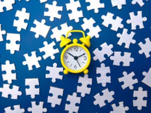 yellow-alarm-clock-and-white-puzzle-on-a-blue-back-2023-11-27-05-02-04-utc